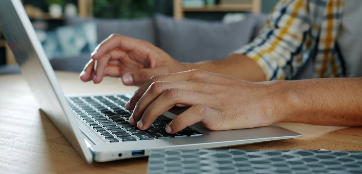 manos de chico tecleando en ordenador
